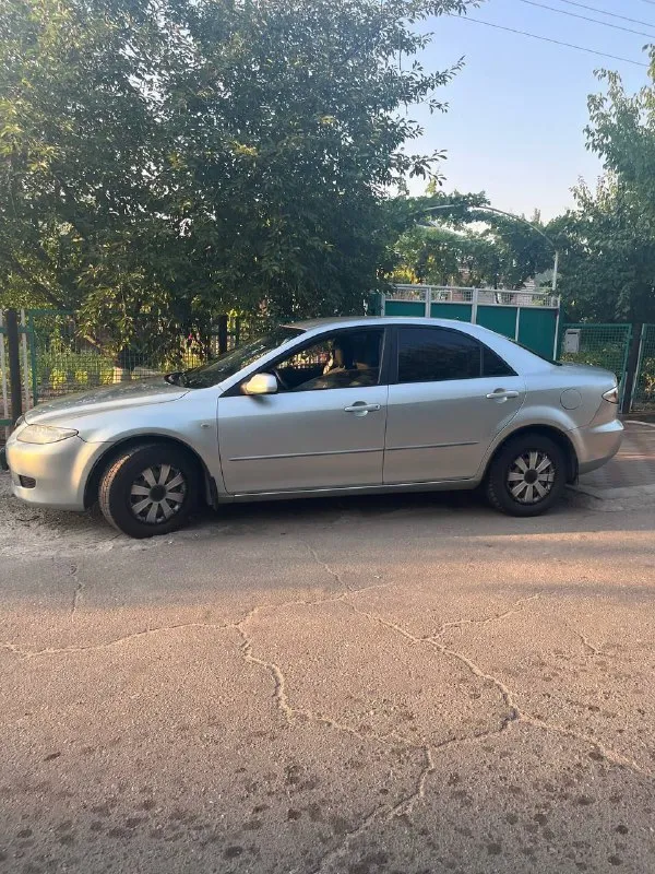 Продает авто mazda 6, год выпуска 2004, в хорошем рабочем состоянии, цвет серый, двигатель 1.8, седан, пробег 270000 км, коробка передач механика с замком, 5-ти ступенчатая, кондиционер. Резина - два комплекта. Цена 450000 руб, возможен торг. Не забывайте, что с 1-го ноября 2025 г. В р. Ф. Вводится утилизационный сбор и авто подорожали от 20 до 50%. Регистрация украина, днр. Возможна до регистрации установка прицепного устройства. Куплена в салоне, один хозяин, грузы не возила. Тел. +79497024830. - фотография - 1